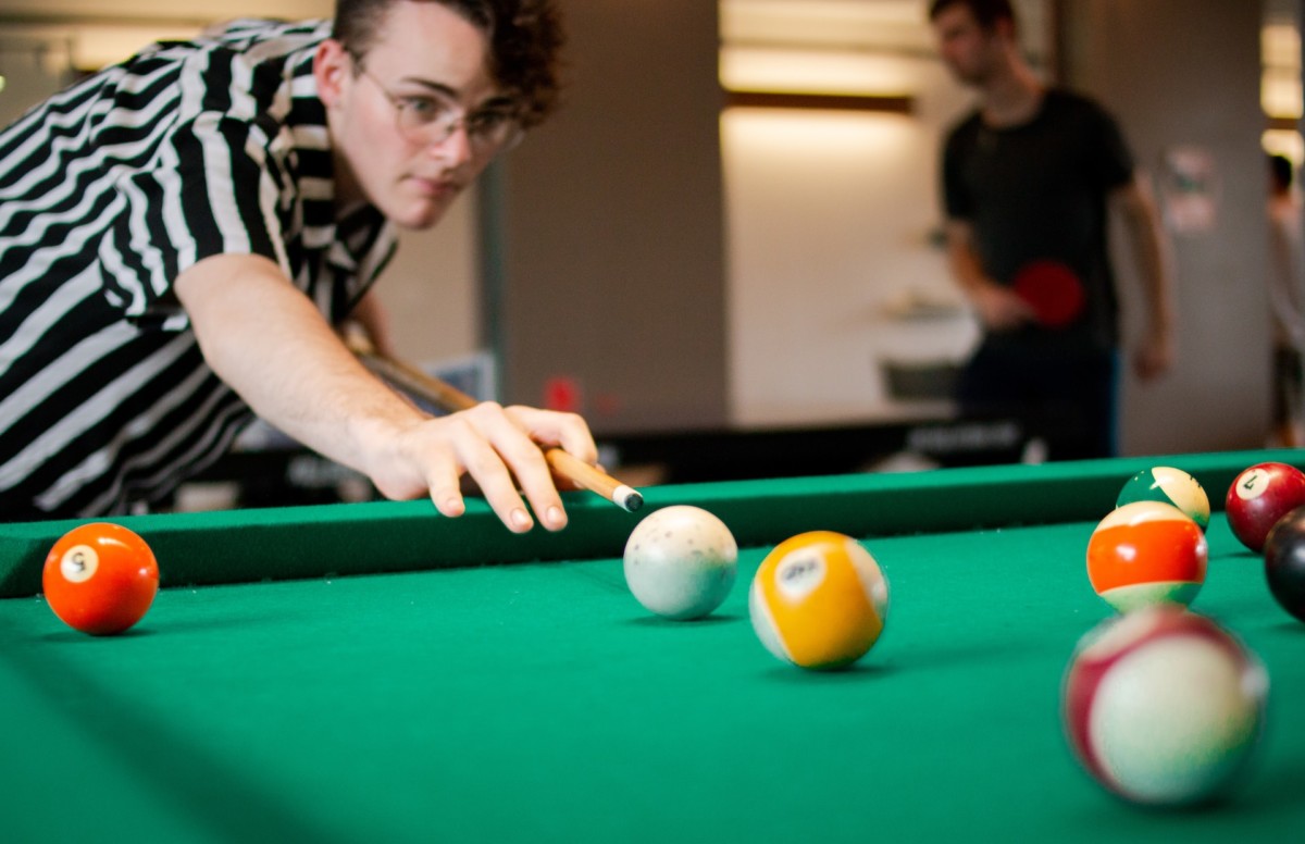 Guy shooting pool